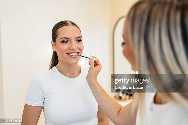 junge frau, die ihr make-up von einer kosmetikerin in einem schönheitssalon lässt sich frisch machen. - permanent make up stock-fotos und bilder