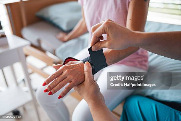 doctor givig female patient wrist brace. rehabilitation and physiotherapy concept. - wrist stock pictures, royalty-free photos & images