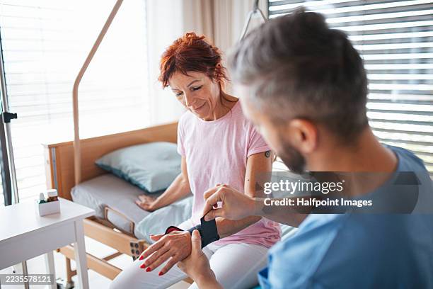 doctor givig female patient wrist brace. rehabilitation and physiotherapy concept. - wrist stock pictures, royalty-free photos & images