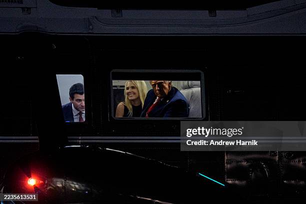 President Donald Trump , accompanied by Tiffany Trump's husband Michael Boulos , and aide Natalie Harp , looks out the window of Marine One as it...