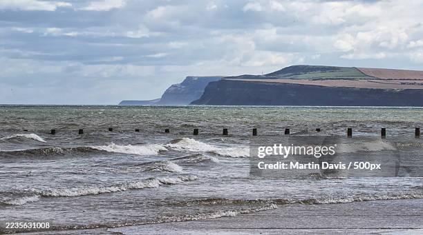 dramatic coastal landscape with a stormy sea and rugged cliffs under a cloudy sky,redcar,united kingdom,uk - redcar stock pictures, royalty-free photos & images