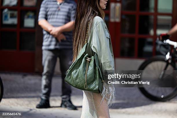 Guest wears green Chanel bag, transparent skirt, jacket outside Bronx and Banco during New York Fashion Week on September 15, 2025 in New York City.