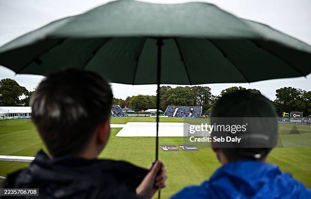 Dublin , Ireland - 19 September 2025; Spectators take shelter as they await play before match two of the T20 International Series between Ireland and...