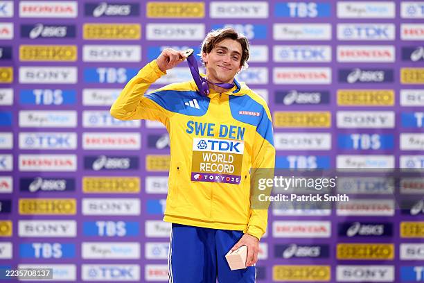 Gold medalist Armand Duplantis of Team Sweden celebrates on the podium whilst wearing a sign reading "WORLD RECORD" after setting a new world record...