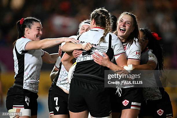 Canada's lock Sophie de Goede is mobbed by teammates after scoring a try during the Women's Rugby World Cup semi-final between New Zealand and Canada...