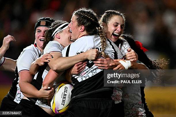 Canada's lock Sophie de Goede is mobbed by teammates after scoring a try during the Women's Rugby World Cup semi-final between New Zealand and Canada...