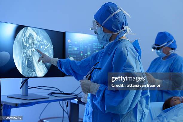 médicos con cascos de realidad virtual (vr) y batas quirúrgicas en un quirófano. tecnología quirúrgica moderna en un quirófano. - neurocirugia fotografías e imágenes de stock