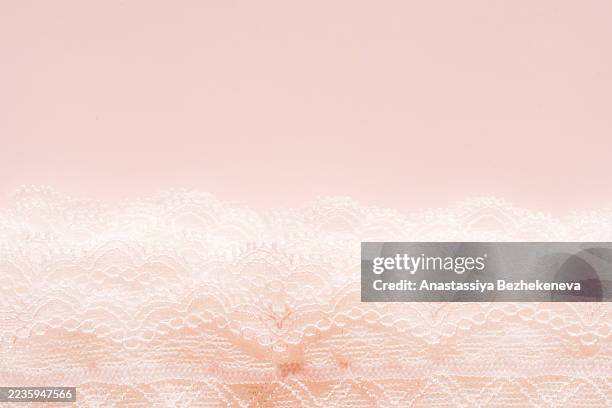 white lace fabric border placed on pink surface - frilly stock pictures, royalty-free photos & images