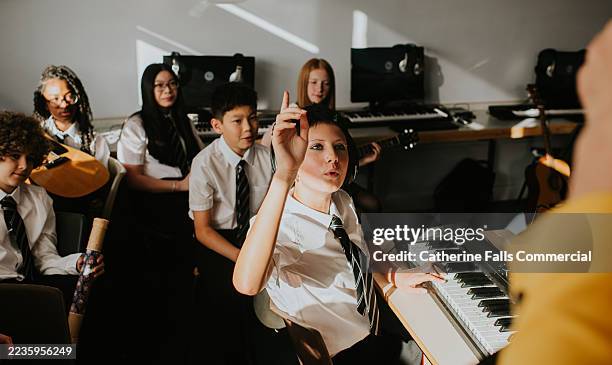 an eager student raises a hand to ask a question to her teacher - menselijke ledematen stockfoto's en -beelden