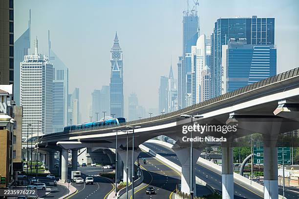 modern elevated transit amidst dubai's iconic skyscraper skyline - elevated train stock pictures, royalty-free photos & images