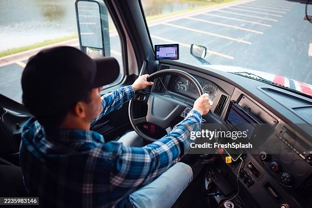truck driver operating vehicle with focus on safety and navigation instruments - vrachtwagenchauffeur stockfoto's en -beelden