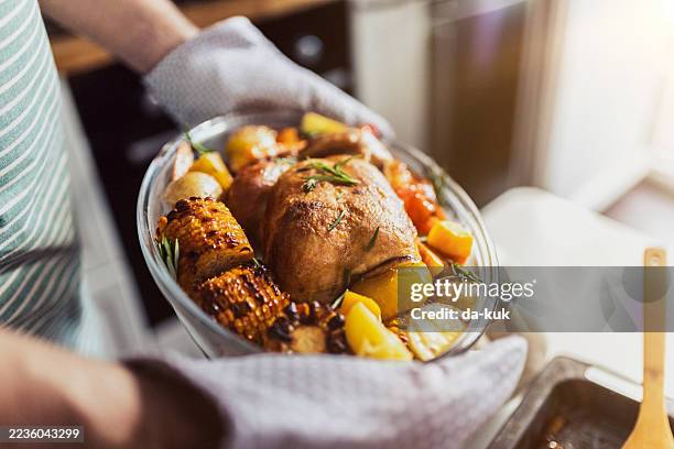 sostener pavo asado con verduras a la parrilla en una cocina moderna - plato de carne fotografías e imágenes de stock