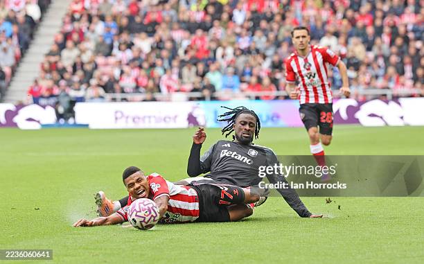 Reinildo Mandava of Sunderland is tackled by Evann Guessand of Aston Villa during the Premier League match between Sunderland and Aston Villa at...