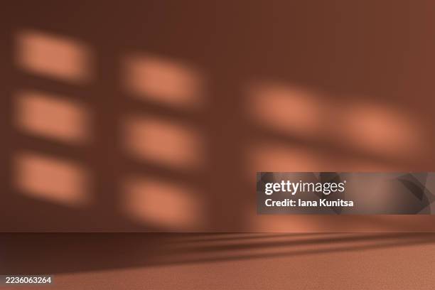 minimal abstract empty 3d studio background with soft sunlight shadows on a dark brown wall and floor. warm natural light creates a cozy atmosphere, ideal for modern design, interior concepts, and creative presentations. - shadow overlay stock pictures, royalty-free photos & images