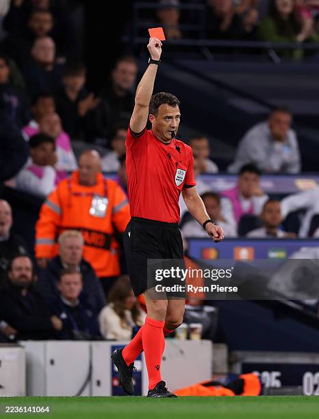 Referee Felix Zwayer shows a red card to Giovanni Di Lorenzo of Napoli following a foul on Erling Haaland of Manchester City during the UEFA...