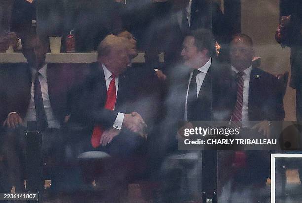 President Donald Trump and Tesla CEO Elon Musk shake hands during the public memorial service for right-wing activist Charlie Kirk at State Farm...