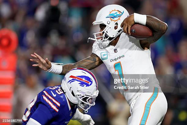 Tua Tagovailoa of the Miami Dolphins runs with the ball in the first half of the game against the Buffalo Bills at Highmark Stadium on September 18,...