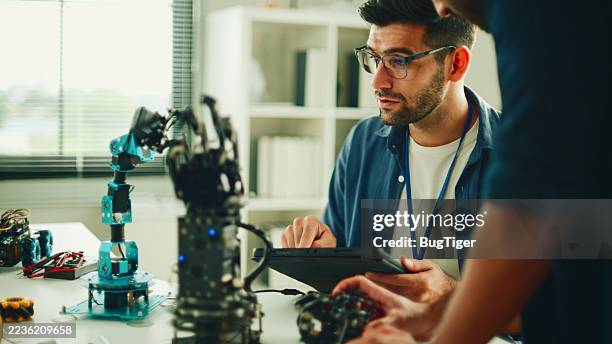 group team work programmer and engineer working ai robot arm system. - video game programmer stock pictures, royalty-free photos & images
