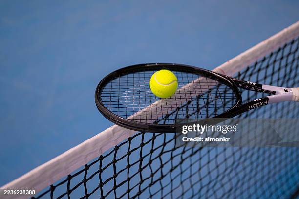 tennista abilmente bilanciando la palla sulla racchetta a rete - racchetta da tennis foto e immagini stock