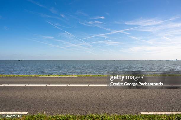 seaside road with blue sky and ocean - freie straße stock-fotos und bilder