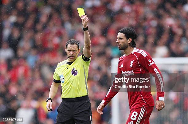 Referee Darren England shows a yellow card to Dominik Szoboszlai of Liverpool during the Premier League match between Liverpool and Everton at...