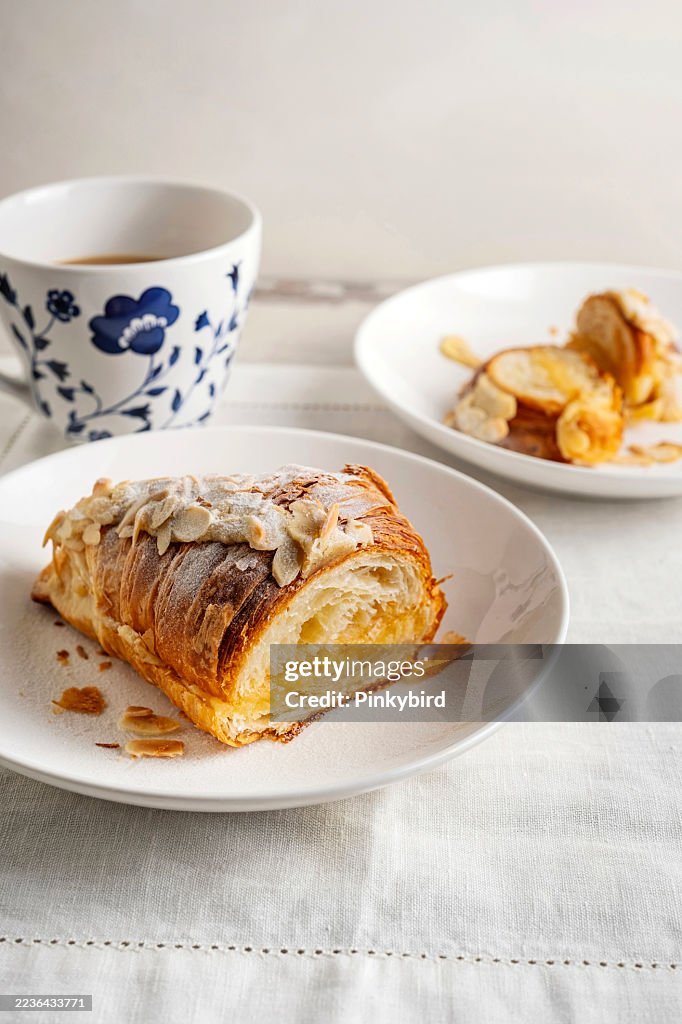 Croissant. Almond croissant. Almond puff pastry sweet dessert fresh delicious. Traditional French breakfast with gold and crispy croissants. Freshly Baked Almond Croissant With Cafe.