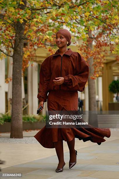 Guest wearing brown head scarf, brown bomber jacket, midi flare skirt and brown tights outside Roksanda during London Fashion Week on September 20,...