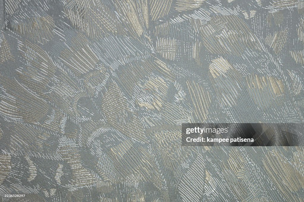 An abstract patterned fabric with grey colors striped background