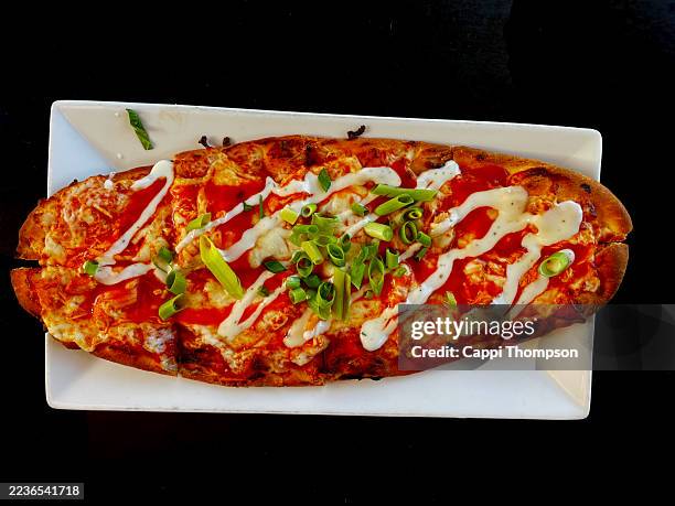 buffalo chicken pizza over black background - buffalo chicken tenders stock pictures, royalty-free photos & images