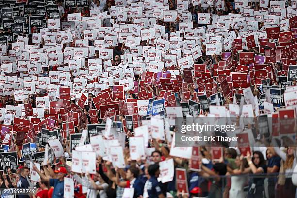 Attendees hold up signs at the memorial service for political activist Charlie Kirk at State Farm Stadium on September 21, 2025 in Glendale, Arizona....