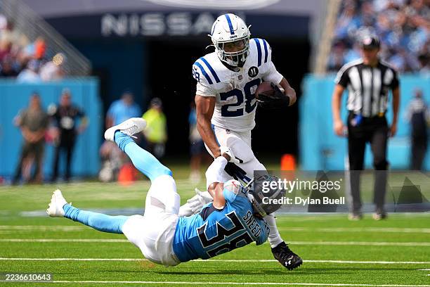Jonathan Taylor of the Indianapolis Colts runs with the ball against L'Jarius Sneed of the Tennessee Titans during the third quarter at Nissan...