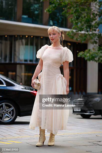 Lola Clark wearing shoulder puff light beige pink dress, beige lace up boots and light pink beige bag brown fur coat and Simone Rocha outside Simone...