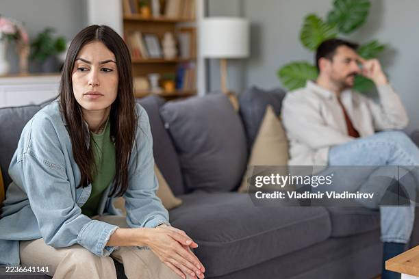 pensive woman lost in thought in a quiet living room - divorce stock pictures, royalty-free photos & images