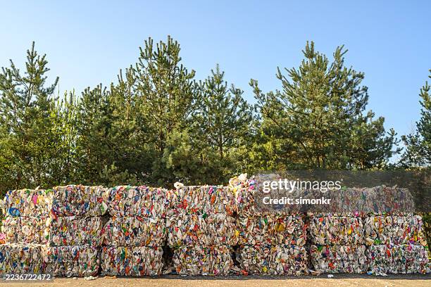 stacked recycled plastic bales at recycling center - circulaire economie stockfoto's en -beelden