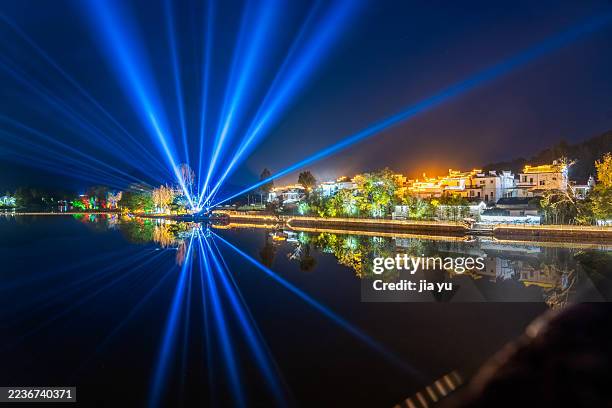 beautiful night view with colorful laser beams reflecting on water - lasershow stock-fotos und bilder