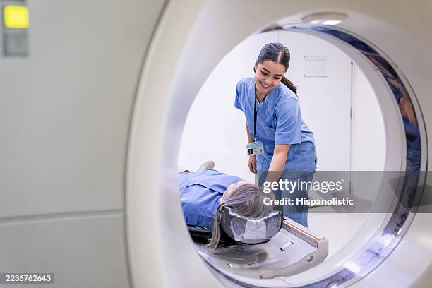 techniker, der einen patienten im krankenhaus auf einen cat-scan vorbereitet - magnetresonanztomographie stock-fotos und bilder