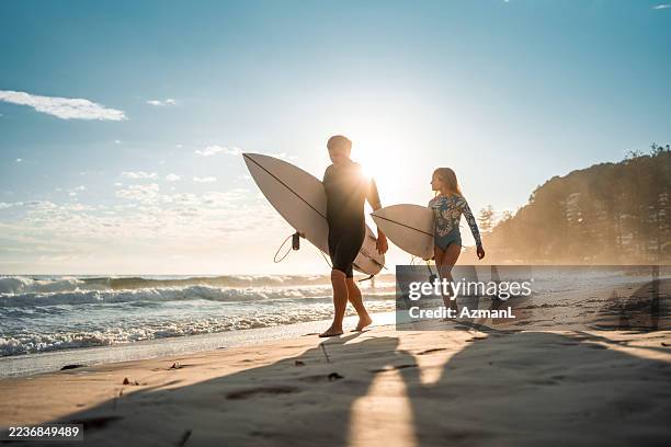 joyful caucasian father and daughter surfing at sunrise - surfing stock pictures, royalty-free photos & images