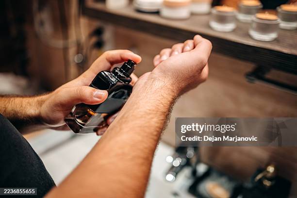 young man at home standing in front of mirror in bathroom and doing morning routine - perfume stock pictures, royalty-free photos & images
