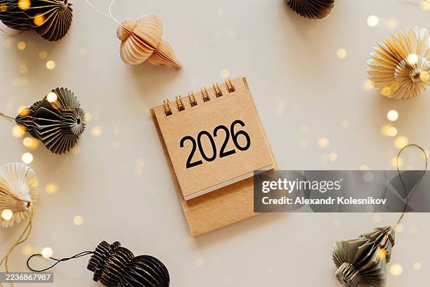 desk calendar for 2026 on the table with copy space. new year decoration with christmas lights. planning of new year concept - 2026 stock pictures, royalty-free photos & images