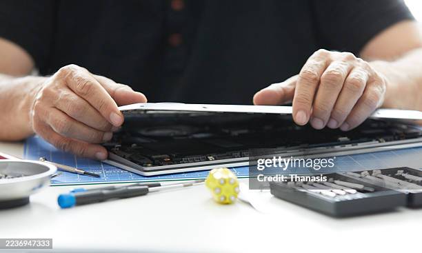 close-up of hands repairing laptop motherboard - computer taken apart stock pictures, royalty-free photos & images