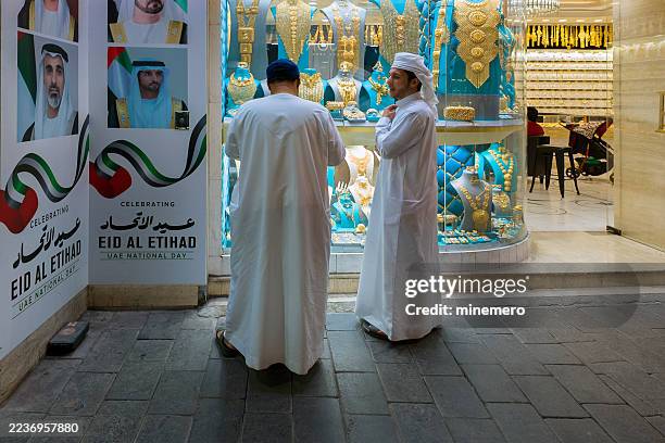 an arab father and son at dubai gold souk - arab people stock pictures, royalty-free photos & images