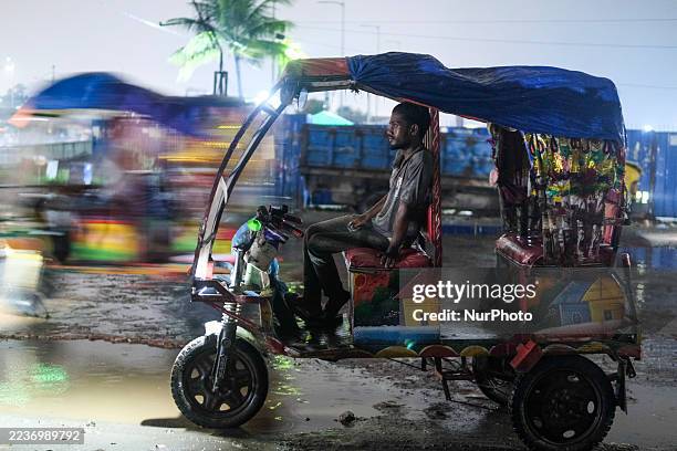 Battery-run auto-rickshaw driver waits for passengers near a highway in Dhaka, Bangladesh, on September 25, 2025.