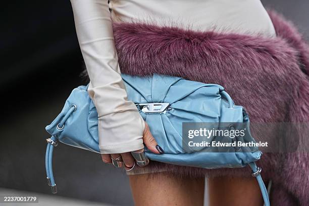 Guest wears a small light blue ruched leather drawstring clutch from Diesel, a long-sleeve fitted pale beige mock-neck mini dress in stretch jersey...