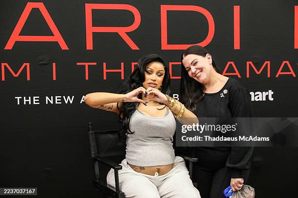Cardi B poses with a fan at the Cardi B "Am I The Drama" meet and greet at Walmart on September 23, 2025 in Houston, Texas.