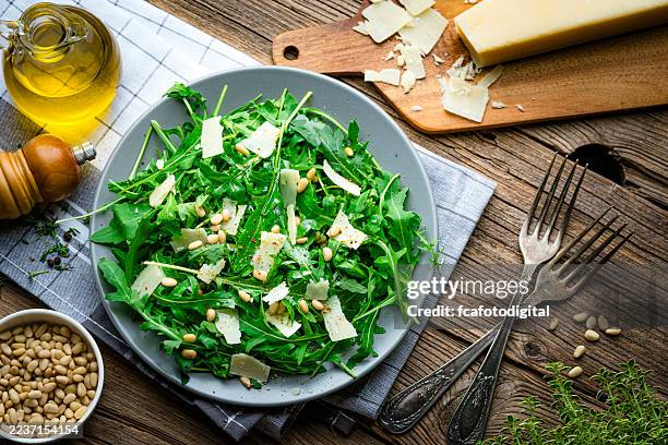 salade de roquette et de parmesan fraîche et saine sur table en bois. cuisine méditerranéenne pour la santé et le bien-être. farine de légumes-feuilles - roquette photos et images de collection