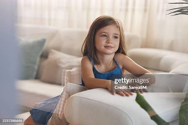 jeune fille assise sur le canapé rêvant - douceur photos et images de collection