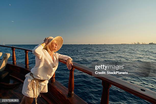 donna che si gode la vista dell'oceano dalla barca al tramonto - albero maestro foto e immagini stock