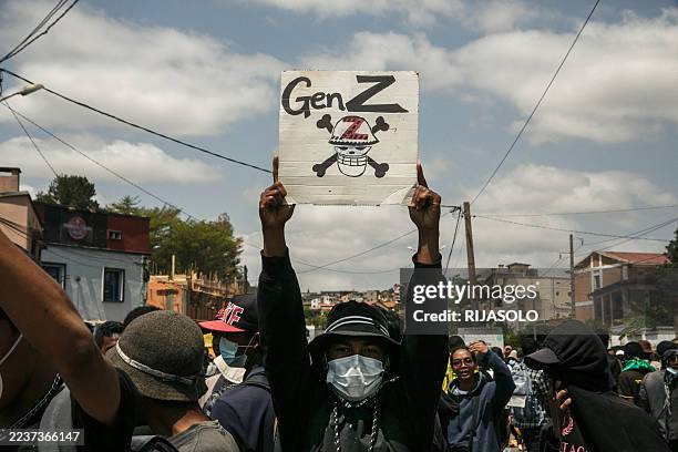 Protester holds a placard during a demonstration against repeated water and electricity outages in Antananarivo on September 27, 2025. Hundreds of...