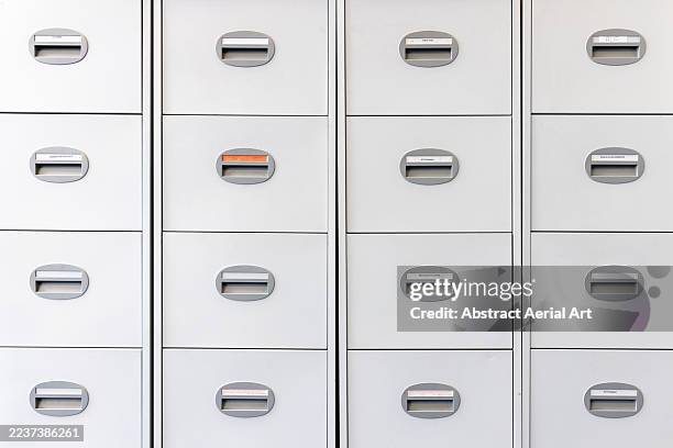 closed drawers in a white coloured filing cabinet with one red coloured label, newcastle upon tyne, england, united kingdom - labeling stock pictures, royalty-free photos & images