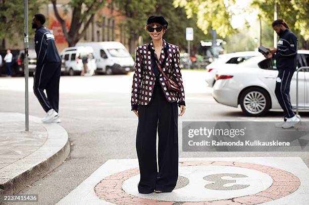 Irina Kro Eicke wears a red and grey check blazer with black wide-leg trousers, styled with a navy beret, black sunglasses, a red quilted handbag,...